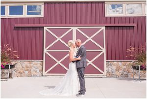 couple standing in front of barn doors at pineview acres