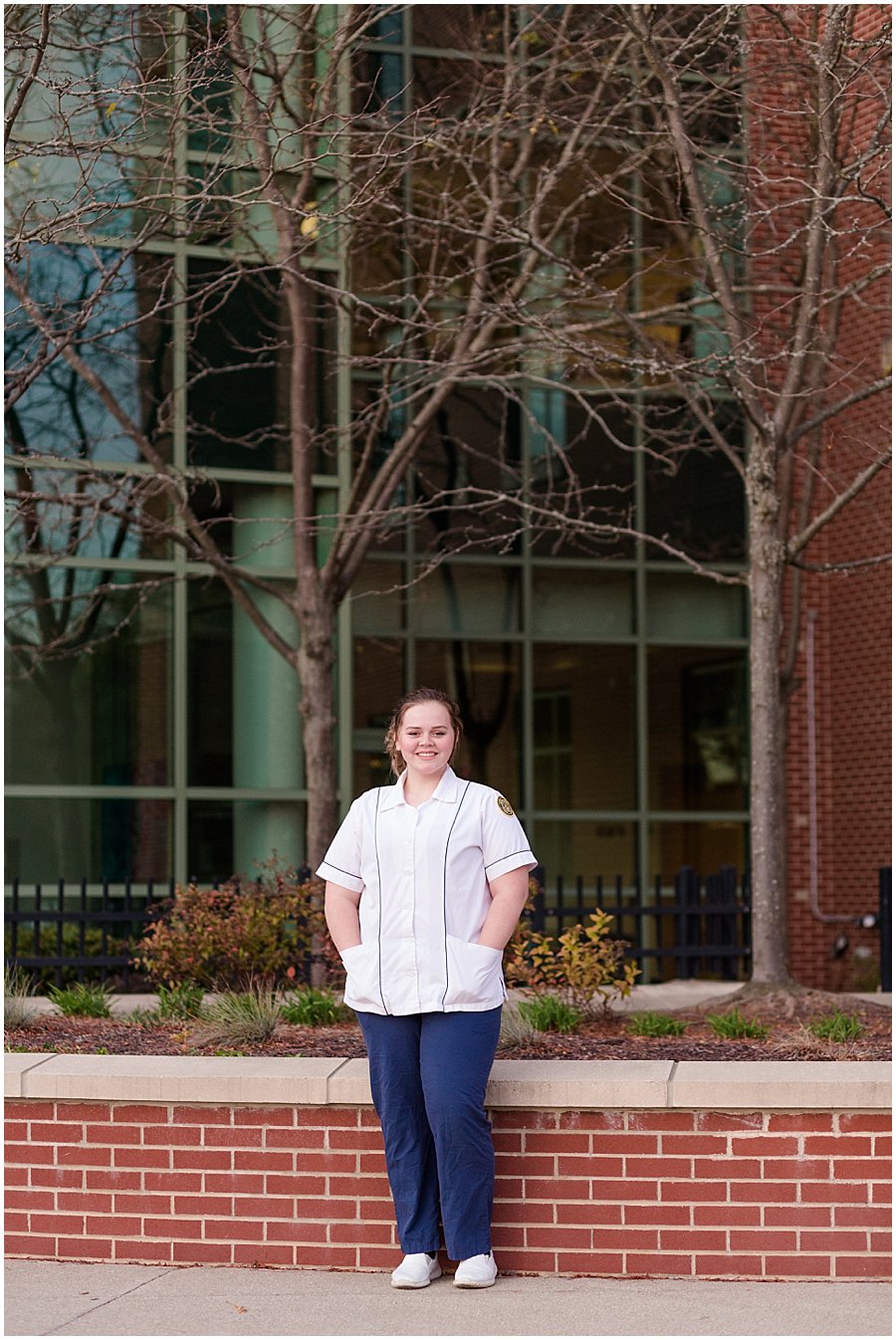 high school senior girl standing in front of Wooster Hospital in her scrubs