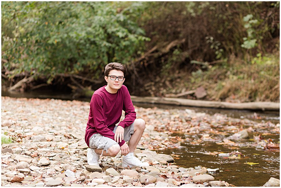 waynedale high school guy squatting by water on fredericksburg trail, photographed by Jamie Lynette Photography