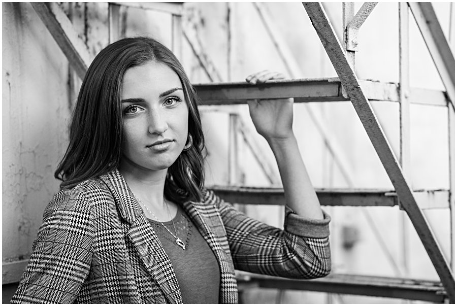 waynedale high school senior female standing under white/rusted steps downtown Wooster Ohio, photo is black and white