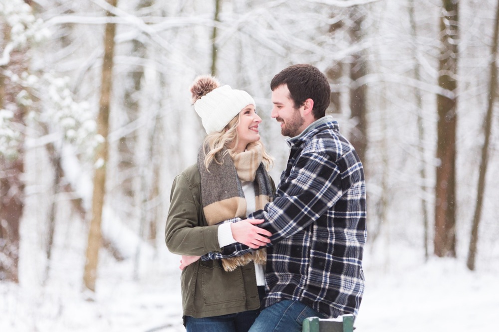Romantic Quail Hollow winter engagement photos with snow-covered pine trees as the backdrop