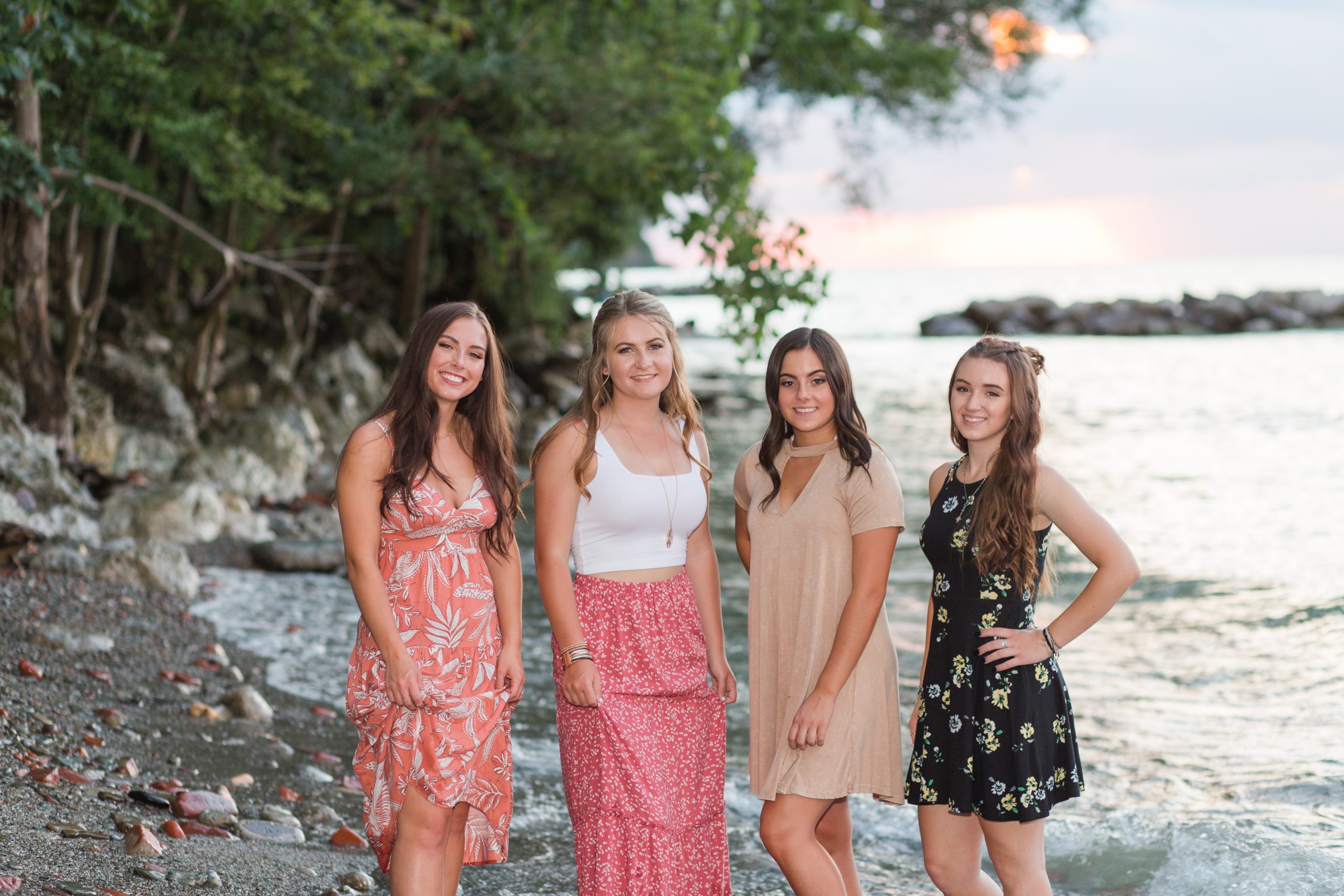 four girls standing on the beach with cute dresses on
