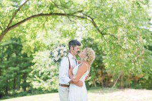 Bride and Groom standing under a tree, looking at each other