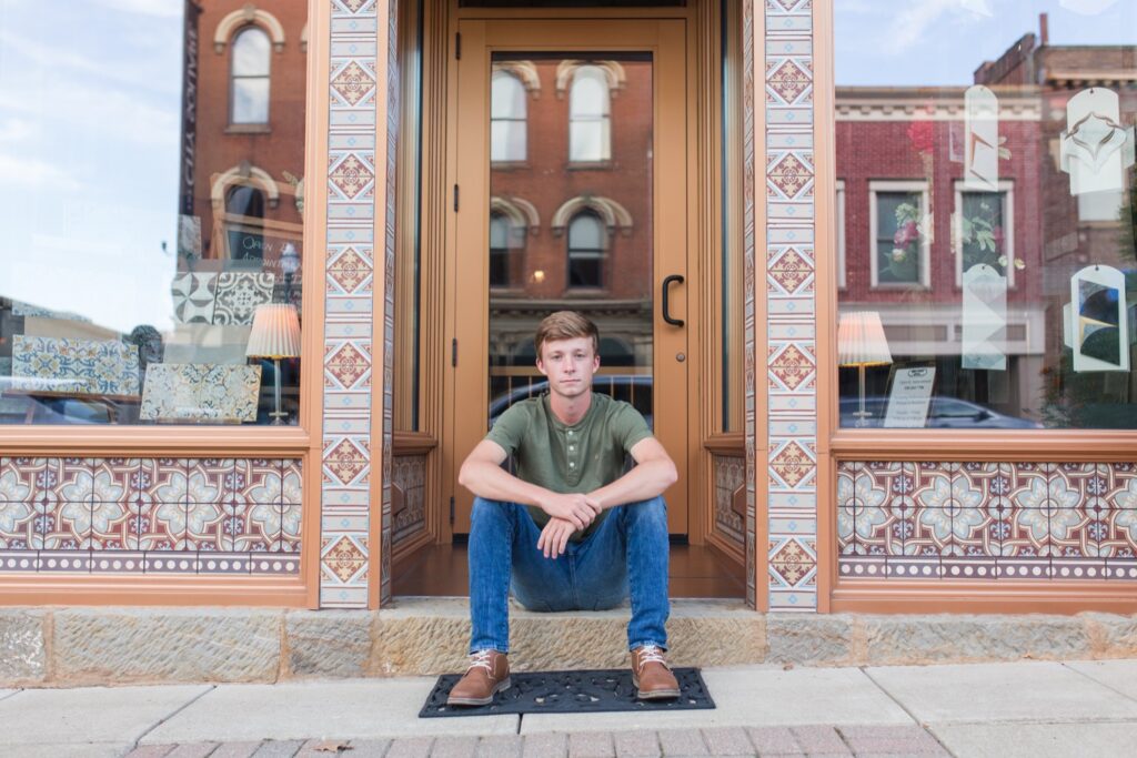 Urban senior portrait with vintage storefront in Wooster
