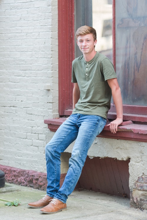 Senior guy sitting in alleyway