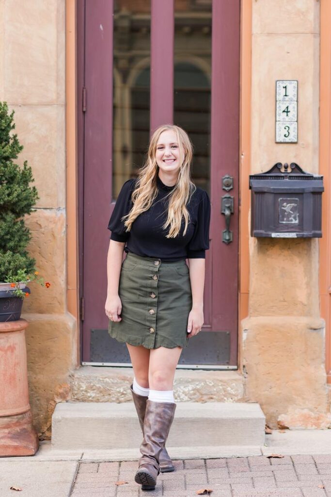 Emma poses confidently during her senior girl photo session in an urban setting