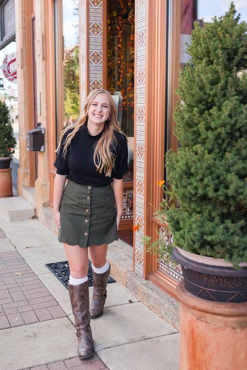 Emma poses confidently during her senior girl photo session in an urban setting