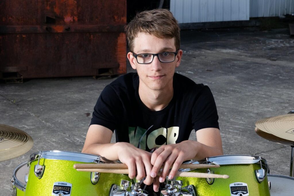 Buddy drumming in front of a grungy urban location, senior inspired drum session. 