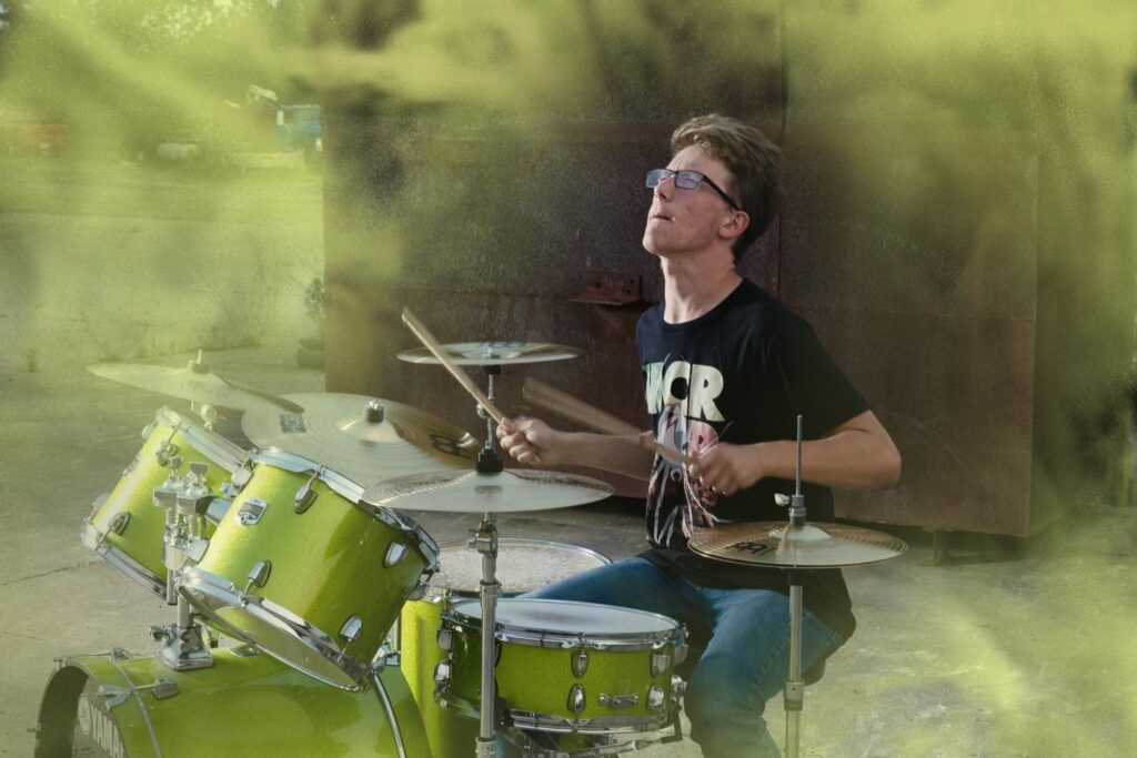 Buddy drumming in front of a grungy urban location, senior inspired drum session. Smoke bomb effect added in photoshop.