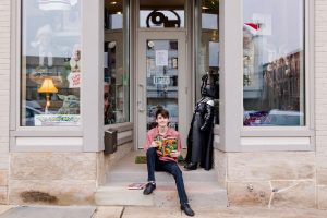senior guy downtown wooster sitting on operation fandom steps with comic book