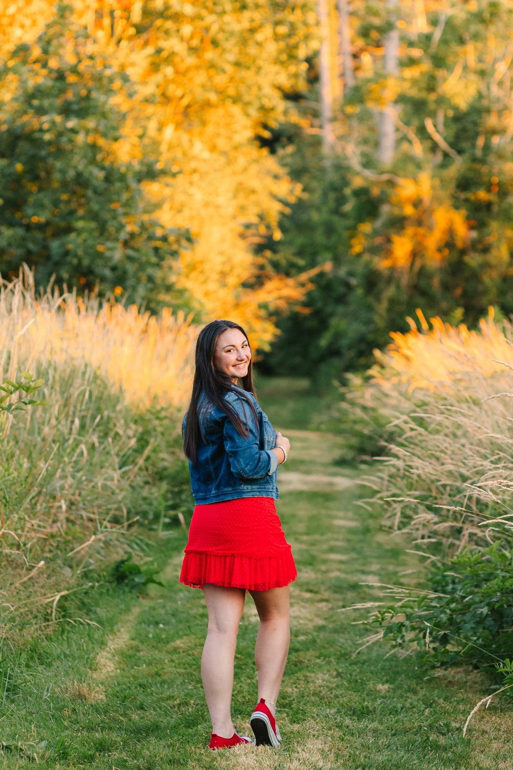 High school senior girl posing in a fall field at OARDC Wooster Ohio during golden hour