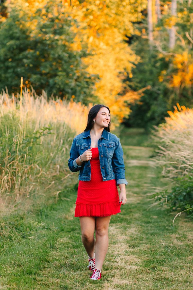 High school senior girl posing in a fall field at OARDC Wooster Ohio during golden hour