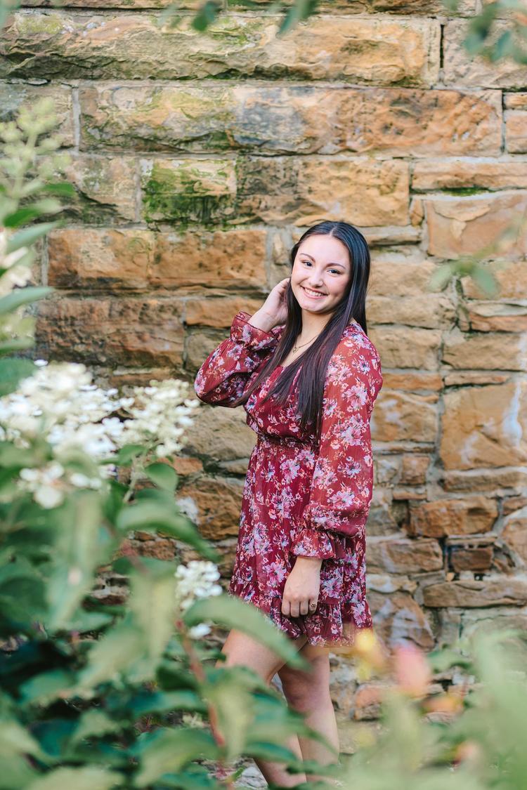 Senior girl posing in a flower bed at OARDC in Orrville Ohio