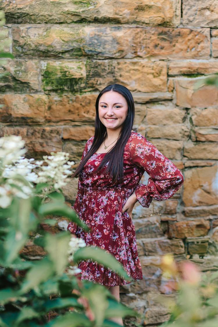 Senior girl posing in a flower bed at OARDC in Orrville Ohio