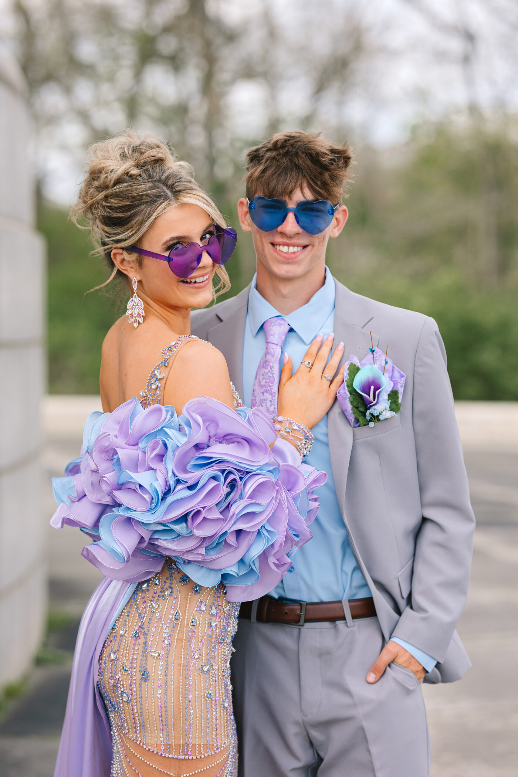 the cute couple having fun with heart shaped glasses during their prom pictures.